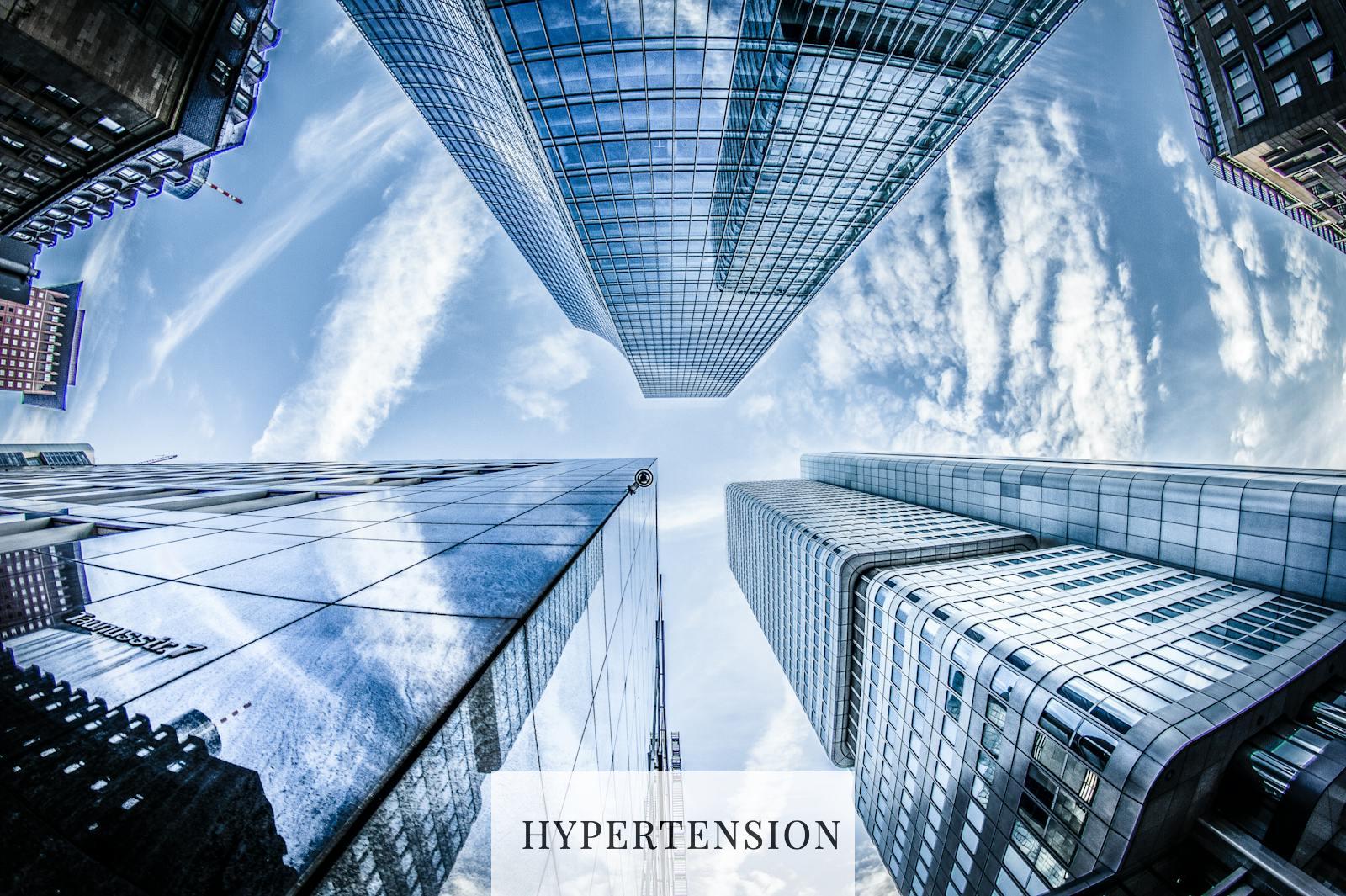 Low-angle Photo of Four High-rise Curtain Wall Buildings Under White Clouds and Blue Sky