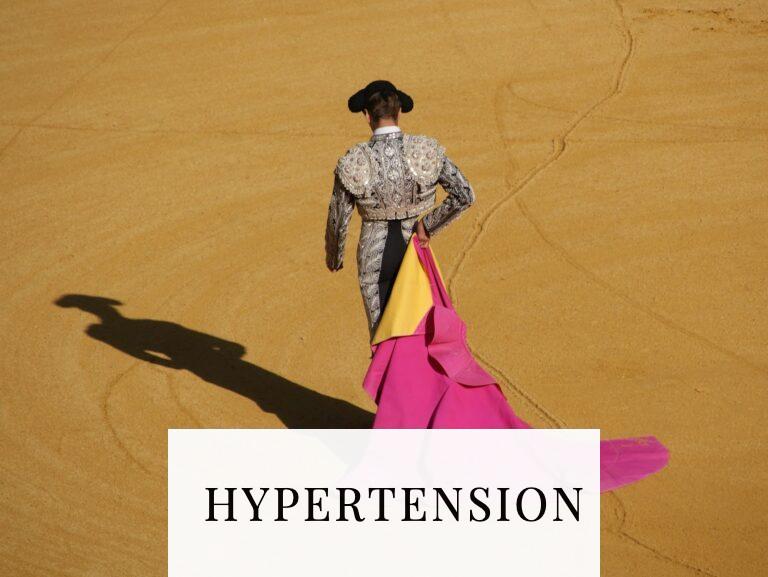 a woman in a pink and yellow dress standing in a desert